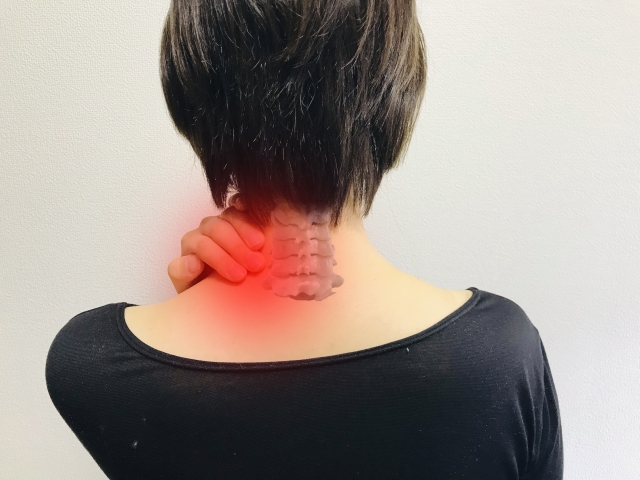 首が痛くて抑える女性